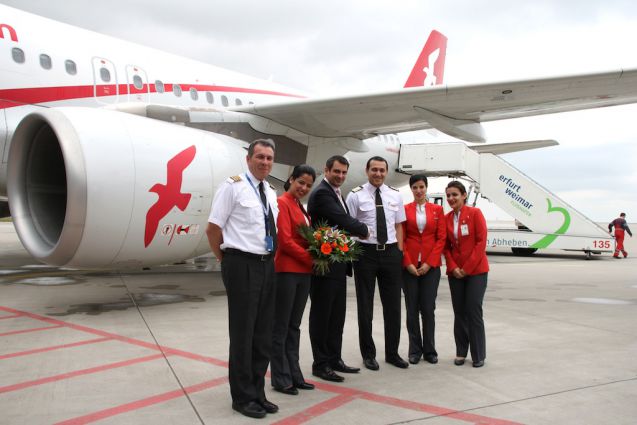 Verkehrsleiter Maurice Lohrke überreicht der Crew Blumen zur Begrüßung. Foto: Alice Koch, Flughafen Erfurt-Weimar