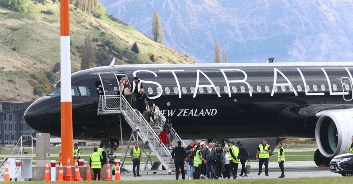 Passagiere verlassen am Flughafen Queenstown ein Flugzeug.