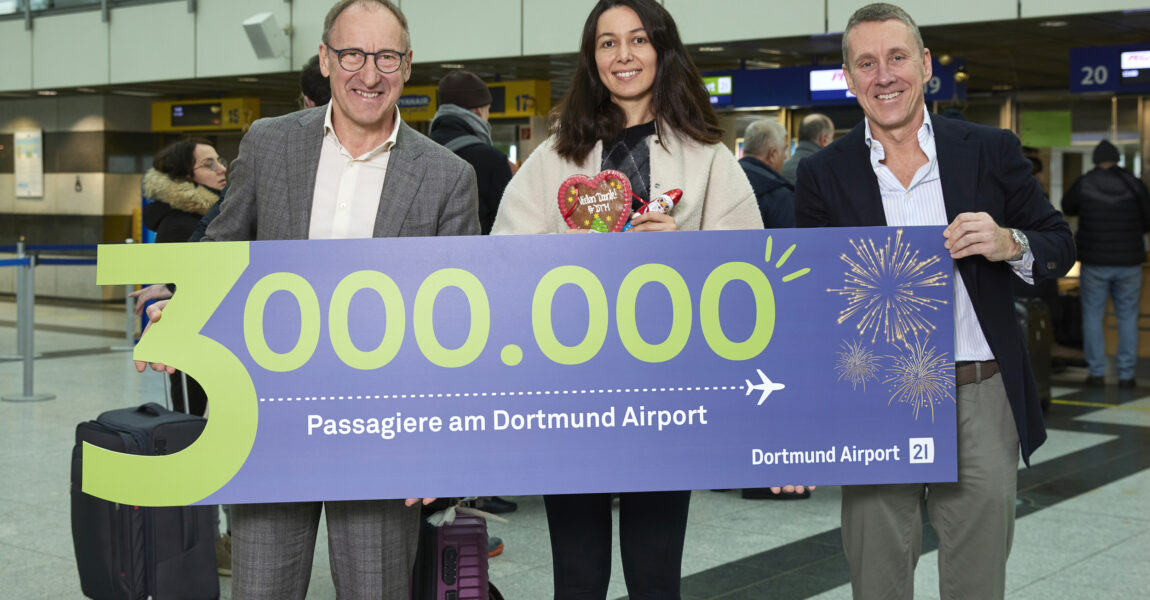 Ludger van Bebber,  die Drei-Millionste Passagierin und Guido Miletic freuen sich über den neuen Rekord am Flughafen Dortmund.