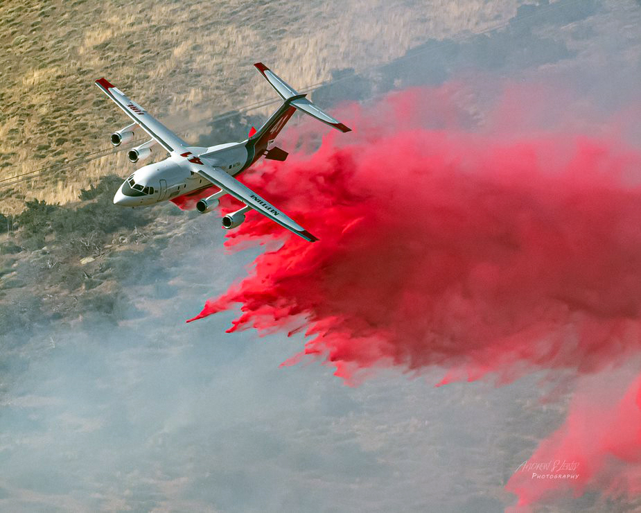 Mit ausgefahrenen Speedbrakes im Heck der Maschine wirft die Crew der BAe 146 ihre rote Wolke aus Löschmitteln ab.